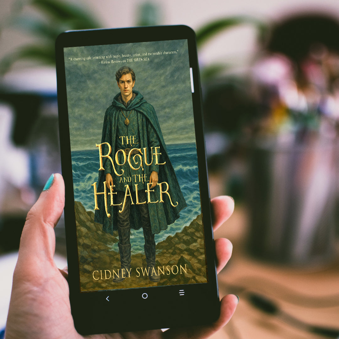 person holding The Rogue and the Healer by Cidney Swanson | lyrical YA fantasy for ages 12–17, part of the Five Kingdoms Chronicles.