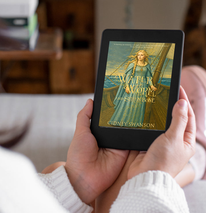 young adult holding Water Worm and Siren Bone by Cidney Swanson | lyrical YA fantasy for ages 12–17, part of the Five Kingdoms Chronicles.