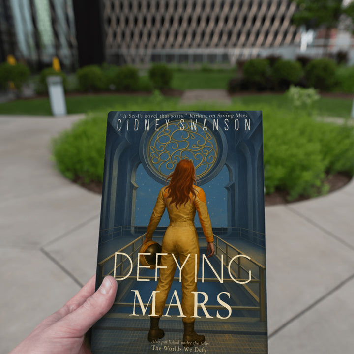 boy holding Defying Mars by Cidney Swanson — clean YA sci-fi for ages 10+, second in the Saving Mars series.