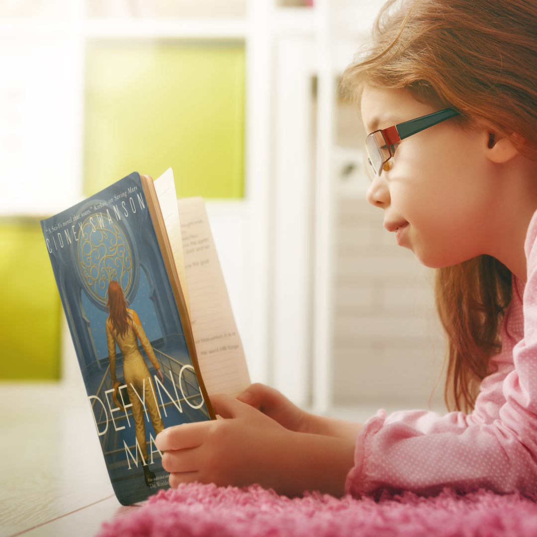 Young girl reading Defying Mars by Cidney Swanson | clean YA sci-fi for ages 10+, part of the Saving Mars series.