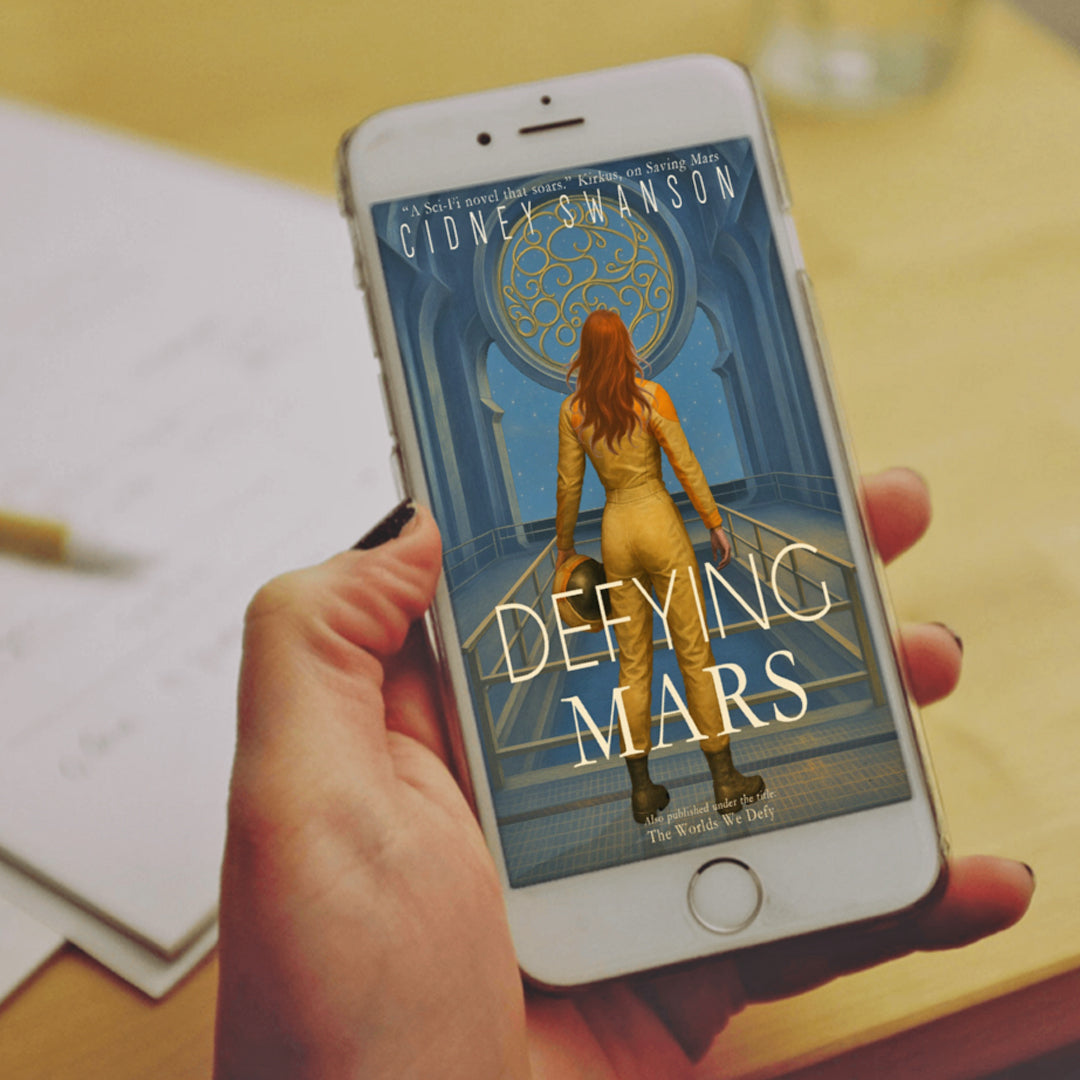 Girl holding Defying Mars by Cidney Swanson | clean YA sci-fi for ages 10+, part of the Saving Mars series.