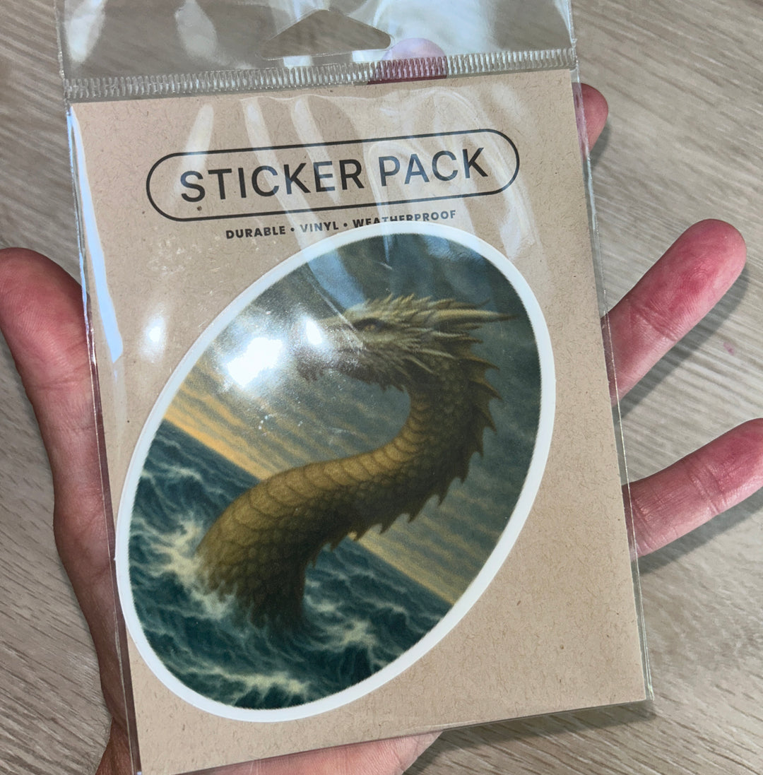 Single oval dragon sticker shown on hand above table.
