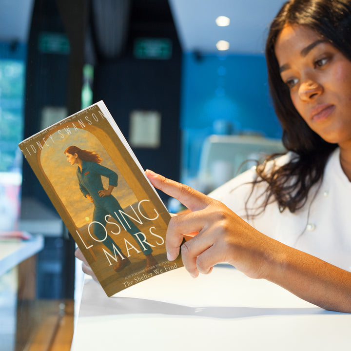 Young woman reading Losing Mars by Cidney Swanson — clean YA sci-fi for ages 10+, third in the Saving Mars series.