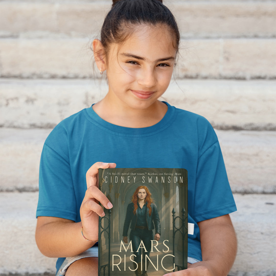 A smiling girl holding Mars Rising by Cidney Swanson — clean YA sci-fi for ages 10+, final book in the Saving Mars series.
