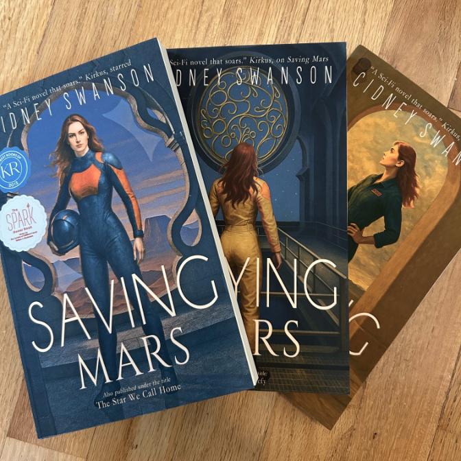 Saving Mars Hardcover bundle on wooden surface