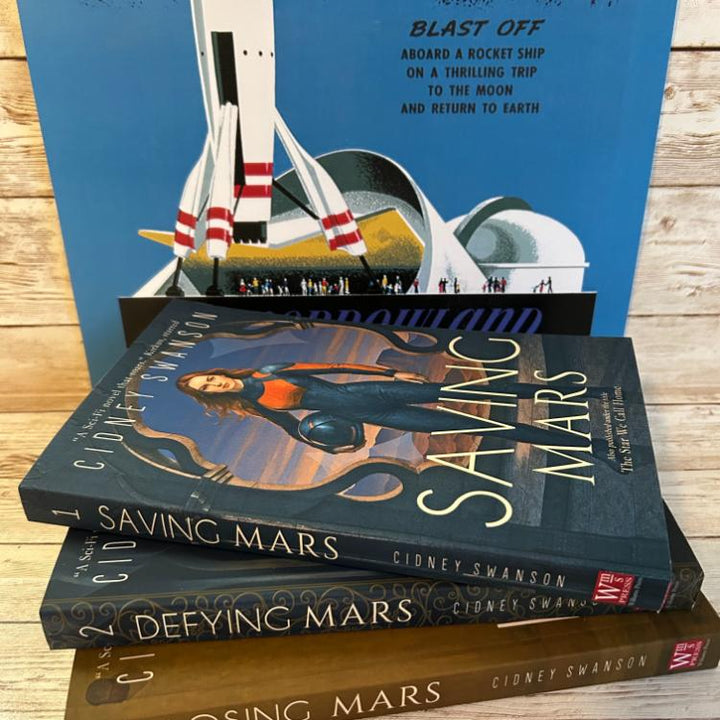 Saving Mars Hardcover bundle on wooden surface alongside memorabilia